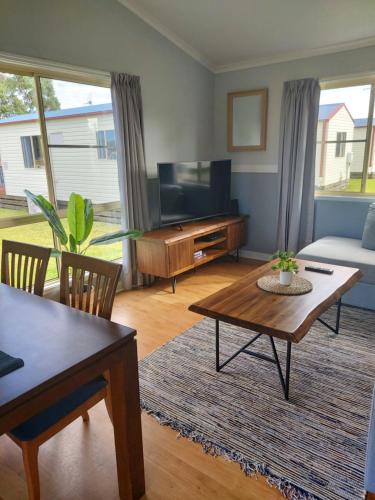 a living room with a television and a coffee table at Stoney Park Holiday Park in Telegraph Point