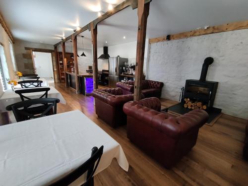 a living room with leather furniture and a fireplace at Triabunna Barracks in Triabunna