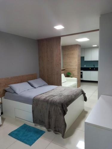 Praia dos Carneiros Flat Hotel Apto Completo في تامانداري: غرفة نوم بسرير كبير ومطبخ