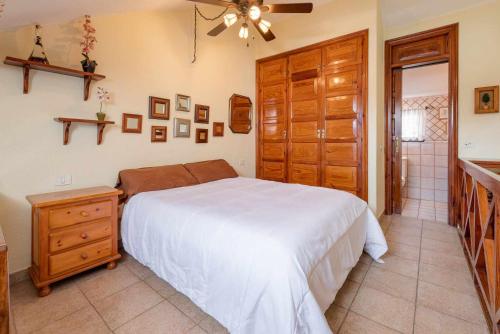 1 dormitorio con cama y armario de madera en Rentaliday Palmera Canaria, en Playa de las Américas