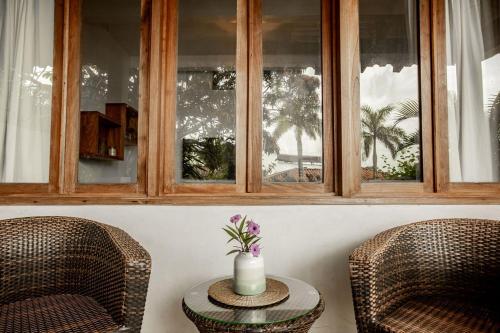 two chairs and a table with a vase on it at Playa Venao Hotel Resort in Playa Venao