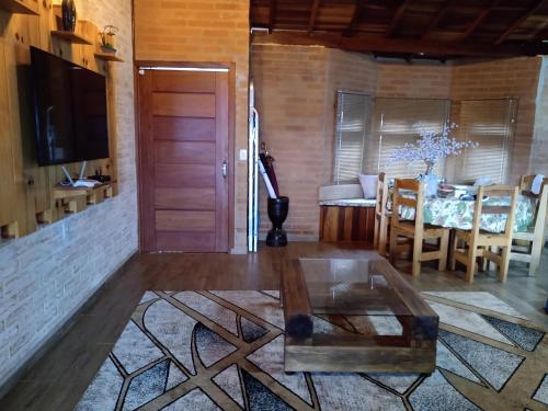 a living room with a table and a dining room at Casa Recanto Beija Flor, Monte Verde in Monte Verde