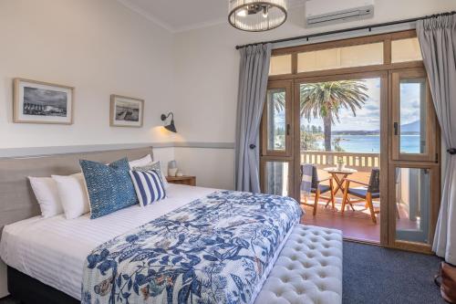 
a bedroom with a large bed and a large window at Bermagui Beach Hotel South Coast in Bermagui

