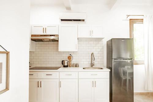 a kitchen with white cabinets and a stainless steel refrigerator at Playa Venao Hotel Resort in Playa Venao