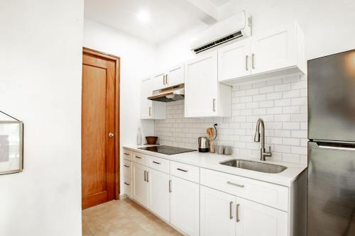 a white kitchen with a sink and a refrigerator at Playa Venao Hotel Resort in Playa Venao