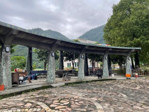 a pavilion with tables and chairs in a park at Ferry Head Leisure Club in Yuanshan
