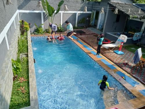 a group of people playing in a swimming pool at Villa Dhanty in Bogor