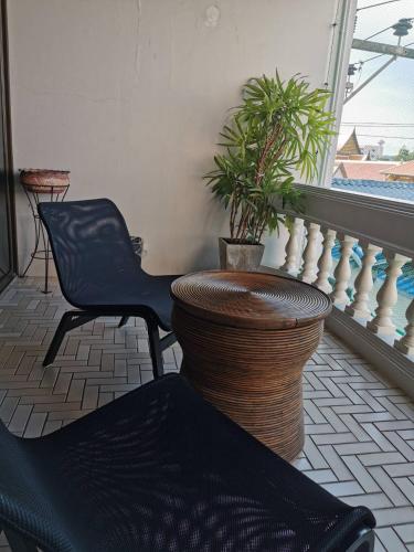 a balcony with a chair and a vase with a plant at BaanBusarin Hotel in Hua Hin