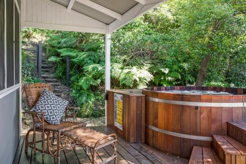 une terrasse avec un bain à remous, une table et des chaises dans l'établissement Rock Davis Luxury Beachouse - 100mtrs to Beach, à Patonga Beach