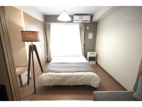 a bedroom with a bed with a large window at UCHI Living Stay Otaru Suitengu in Otaru