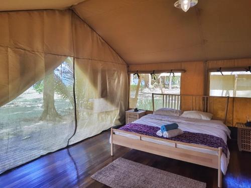 sypialnia z łóżkiem w namiocie w obiekcie Ara Dinawan Island Resort w mieście Papar