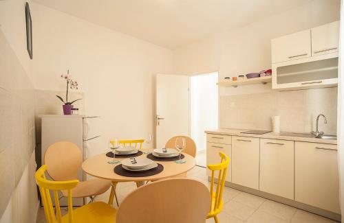 uma cozinha com mesa e cadeiras num quarto em Dalmatian Garden - FREE parking - city centre em Sibenik