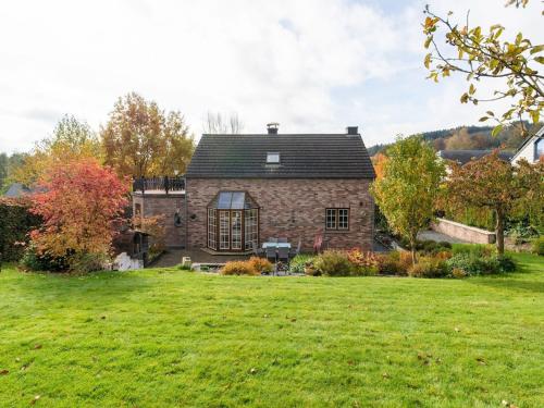 una gran casa de piedra con un patio verde en Holiday Home with Garden Terrace and Jacuzzi in season in Vielsalm en Vielsalm