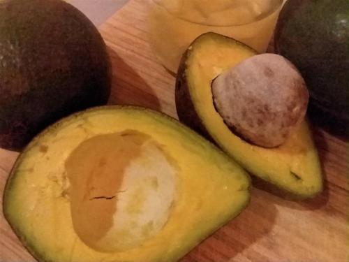 an avocado and some other fruits on a cutting board at Kaireva Beach House in Rarotonga