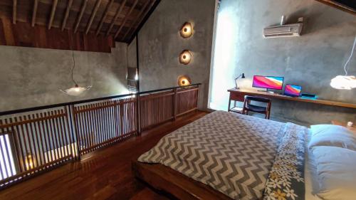 a bedroom with a bed and a desk in it at Ruang Tekuni in Legian