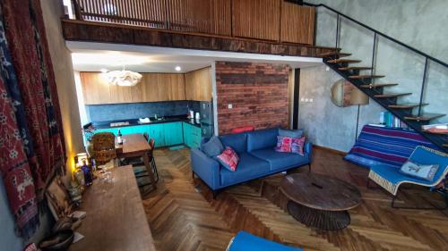 a living room with a blue couch and a table at Ruang Tekuni in Legian