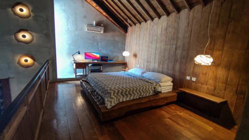 a bedroom with a bed and a desk in it at Ruang Tekuni in Legian