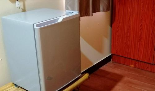 a white refrigerator in a kitchen next to a door at บ้านสวนยายชุ่ม/bannsuanyaychum in Lampang
