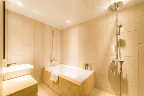 a bathroom with a tub and a sink and a shower at Reborn Suwon Silkroad Hotel in Suwon