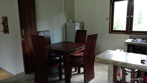 a kitchen with a table and chairs and a refrigerator at Mandara Tree Villas in Kampong Sum Sum