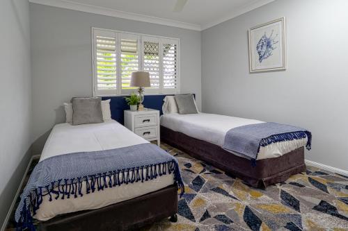 1 dormitorio con 2 camas y ventana en Townsville Southbank Apartments, en Townsville