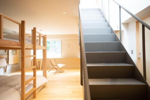 a staircase in a room with a bed and a desk at TAKAONE ACTIVITY＆STAY in Hachioji