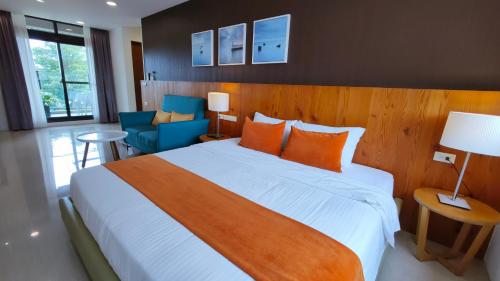 um quarto com uma grande cama branca com almofadas laranja em Riverbank Villa em Luodong