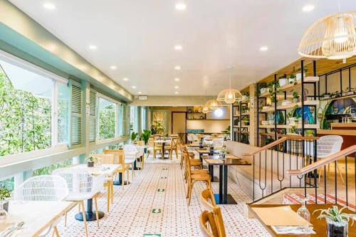 a restaurant with tables and chairs and windows at Hortz Hotels And Resorts in Tagaytay