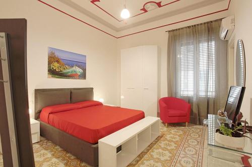 a bedroom with a red bed and a red chair at La Dimora del Massimo in Palermo