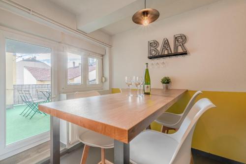 a dining room with a table and chairs and a bar sign at CATTENOM NEW NOVÝ NOWY НОВИЙ - 3 min Parking, Wi-Fi, Nespresso - Repos assuré, calme & confort - Rest guaranteed, quiet & comfy in Hayange
