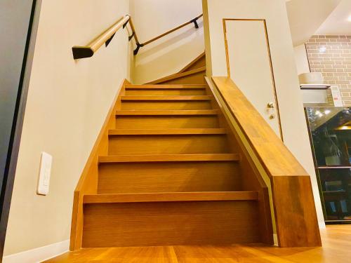 a staircase in a house with wooden steps at HAKATA TERRACE -灯 akari- in Fukuoka