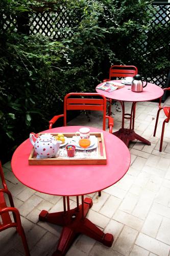 a red table with a tea set on top of it at La Villa Paris - B&B in Paris