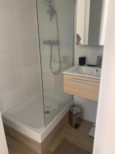 une douche avec une porte vitrée à côté d'un lavabo dans l'établissement studio mezzanine - vue mer - terrasse - parking - literie neuve !, à Sète