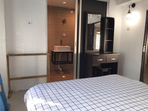 a bedroom with a bed and a sink and a mirror at Kenyalang Urban Homestay in Kuching