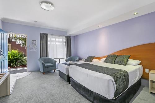 a hotel room with a large bed and a window at Shellharbour Village Motel in Shellharbour
