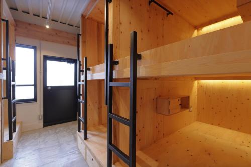 Habitación con paredes de madera y literas. en ITJ Base Shuzenji, en Shuzenji