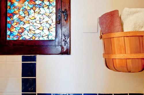 a bathroom with a stained glass window and a basket at B&b Parco Alta Murgia in Cassano delle Murge