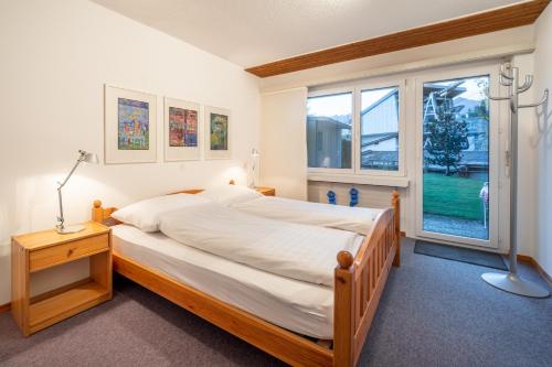 ラアにあるLAAX Homes - Val Signina 4-3のベッドルーム(大型ベッド1台、窓付)