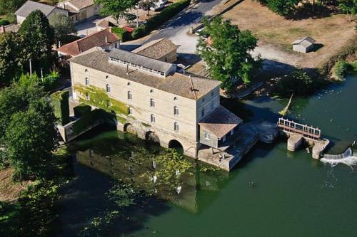 an aerial view of a large building in the water at Une pause quelque part recharge pour voiture électrique inclu in Saint-Médard-de-Guizières
