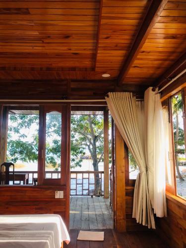 a bedroom with a bed and a large window at Cay Sao Resort in Phú Quốc