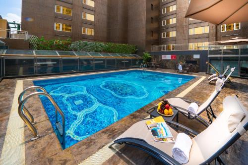 una piscina con sillas y un hotel en Grand Dragon Hotel, en Macau