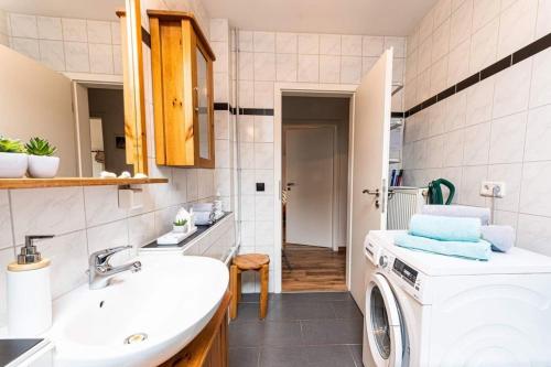 ein Badezimmer mit einer Waschmaschine und einem Waschbecken in der Unterkunft Schalkhaus Regensburg in Regensburg