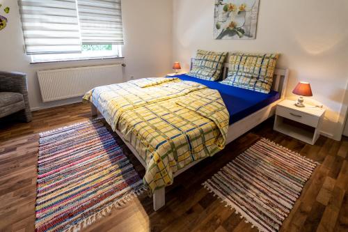 a bedroom with a blue bed and a rug at Ferienwohnung zum-vennwack in Monschau