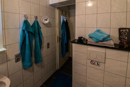 a bathroom with blue robes hanging on a wall at Ferienwohnung zum-vennwack in Monschau