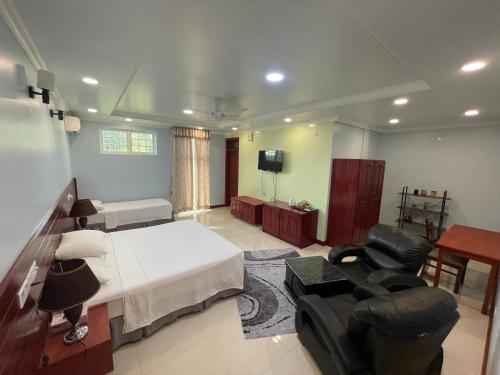 Vista Villa في Hithadhoo: غرفة نوم بسرير واريكة وتلفزيون