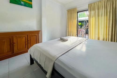 uma cama branca num quarto com uma janela em 711 Gili Trawangan Mitra RedDoorz em Gili Meno