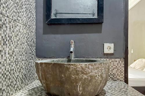 uma casa de banho com um grande lavatório de betão com uma torneira em 711 Gili Trawangan Mitra RedDoorz em Gili Meno