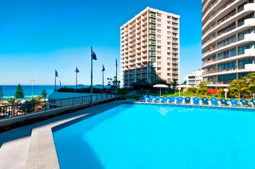 una gran piscina con sillas y un edificio en Surfers International Apartments, en Gold Coast