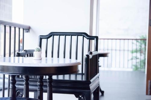 a table and chairs with a potted plant on a porch at The Lantern Hatyai Hotel in Hat Yai
