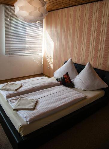a bed with white sheets and pillows in a room at Herzog's Ulsterbrücke in Tann